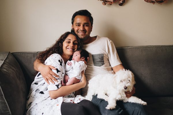 couple smiling with their newborn baby in london home