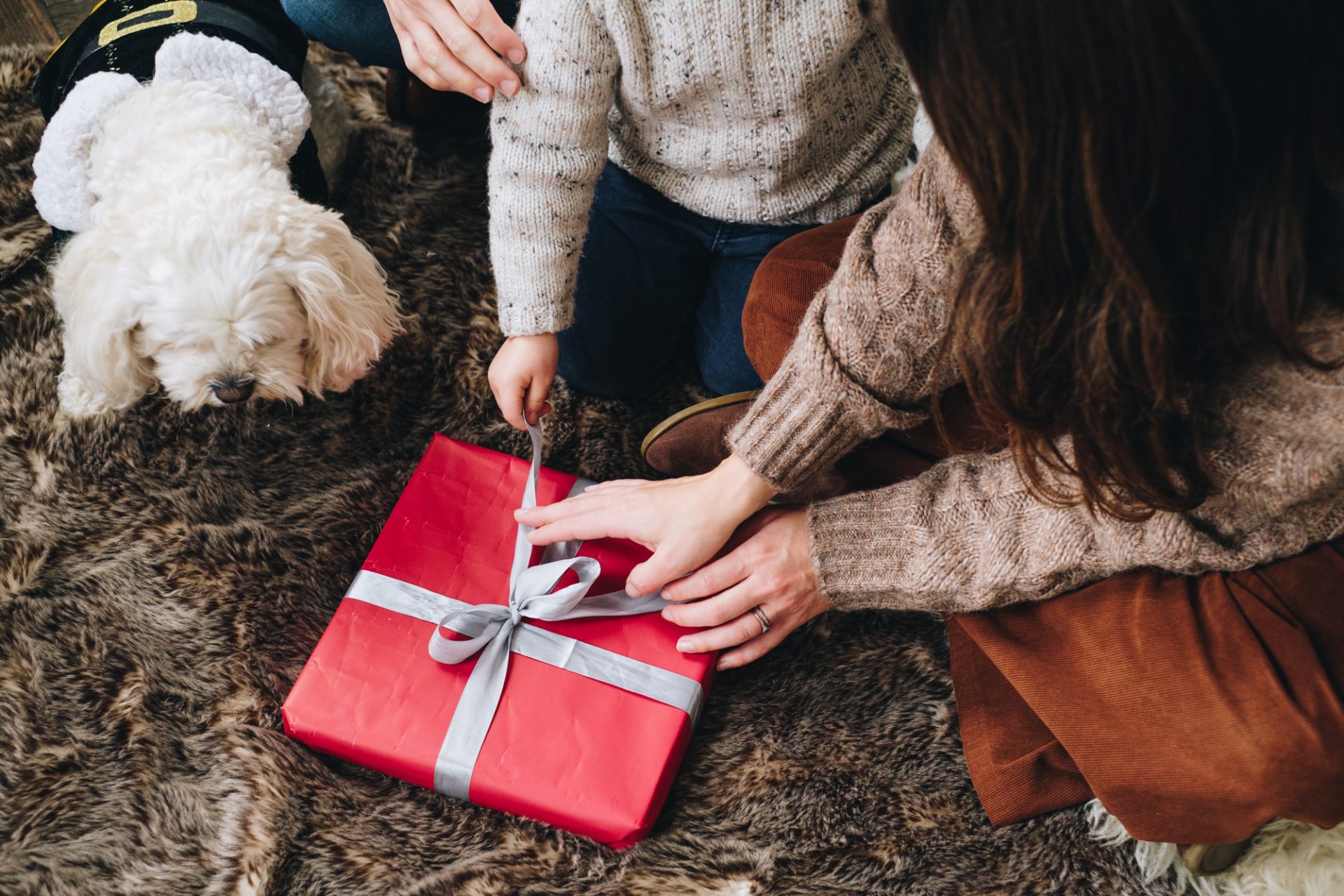 Hands upwrapping a Christmas present