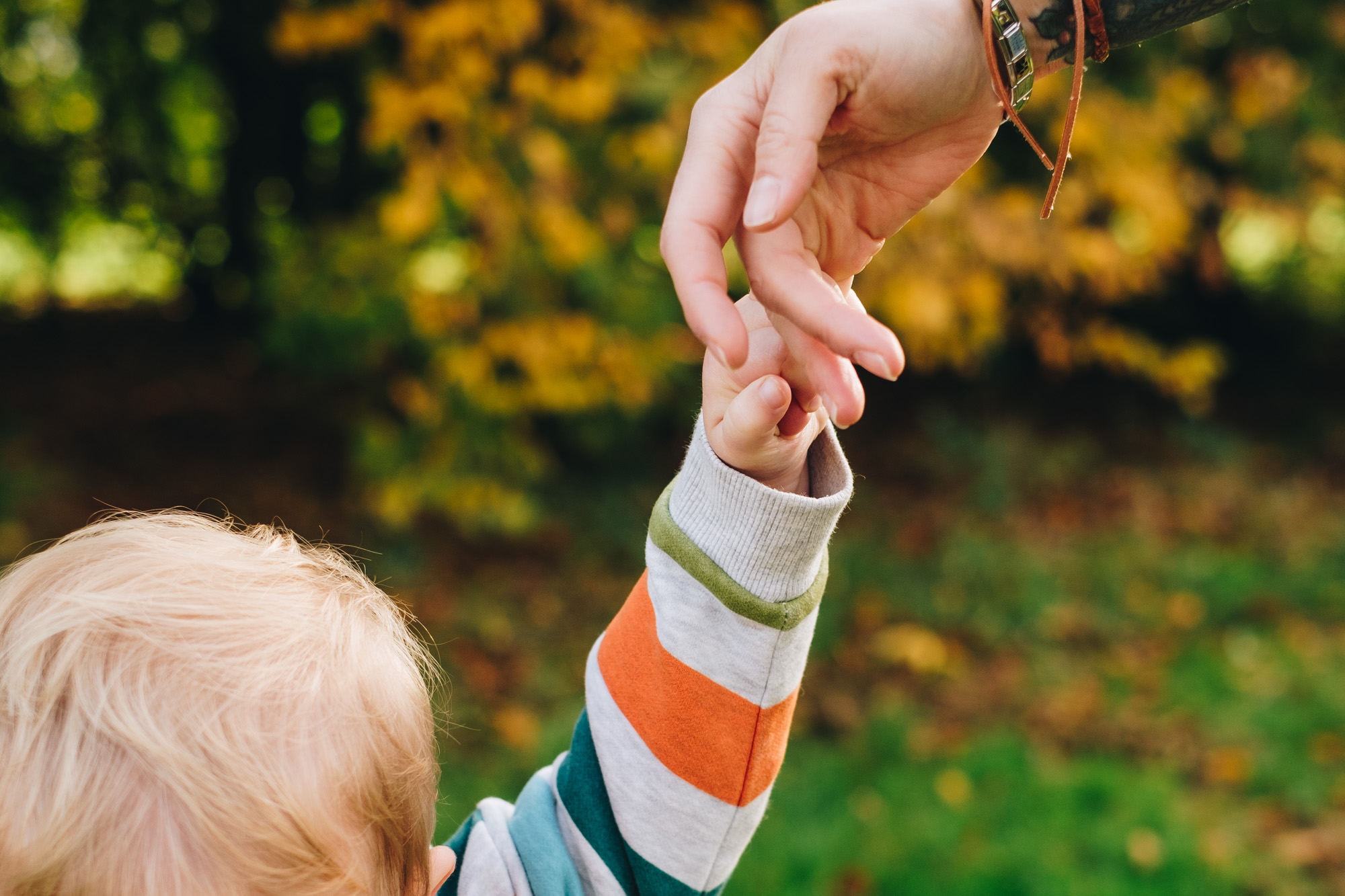 Close up of mum and child holding hands