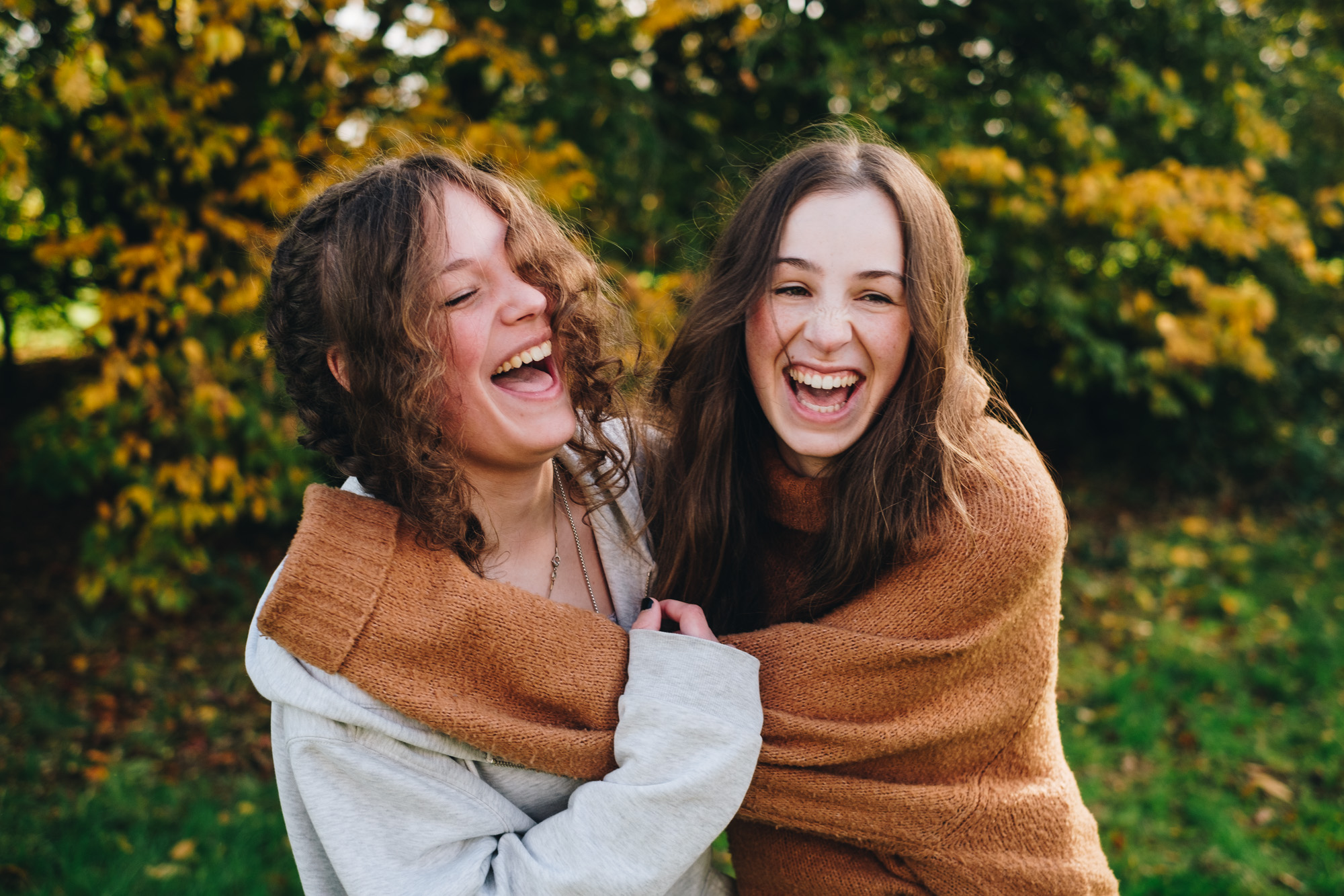 Two sisters laughing while holding each other
