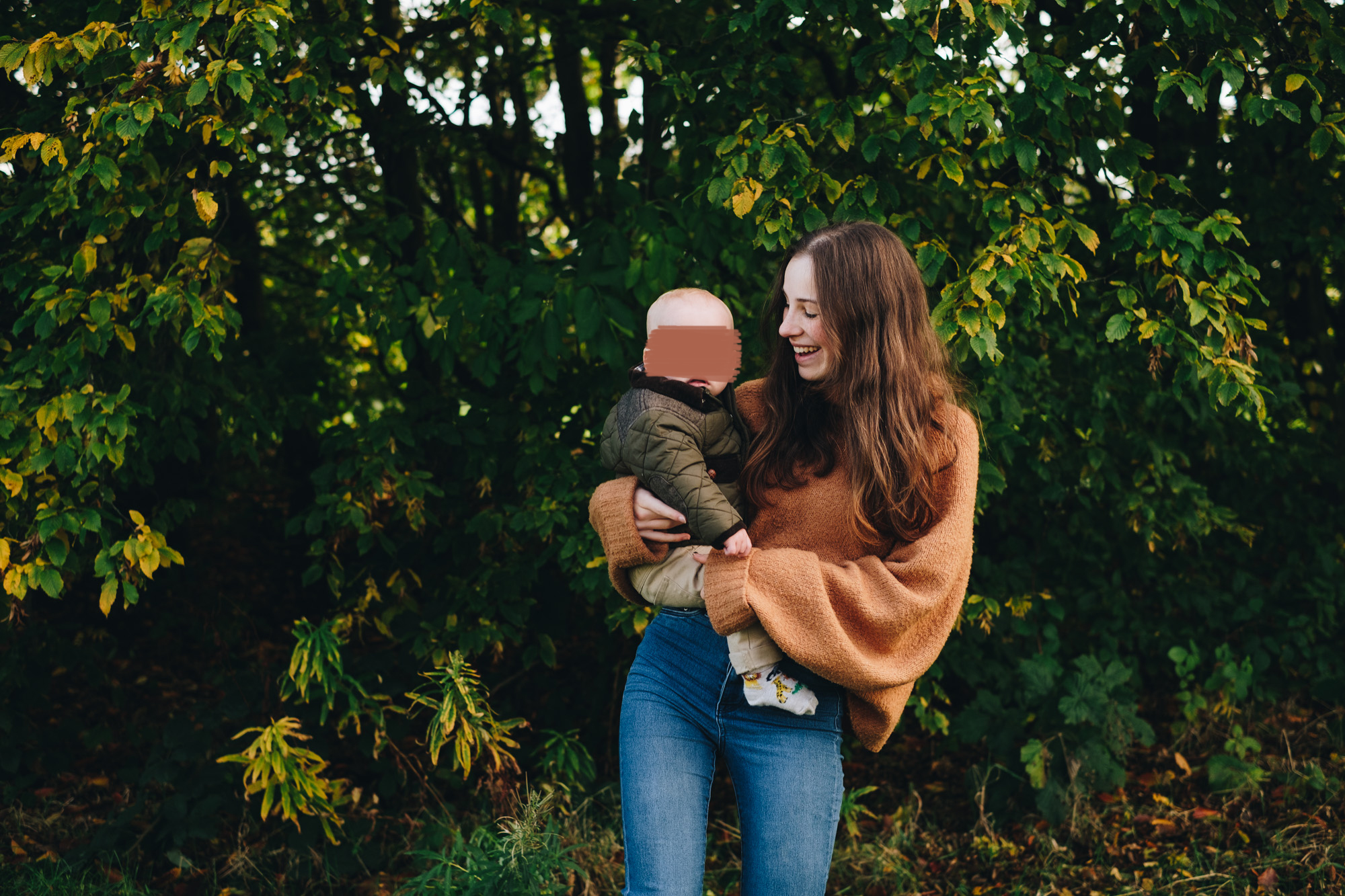 Mum holds her baby on her hip while looking at him